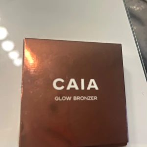 Glow Bronzer från CAIA - Snygg glow bronzer från CAIA i nyansen Antigua. Kommer i en elegant brun förpackning med spegel. Perfekt för att ge ansiktet en solkysst look med en fin lyster.