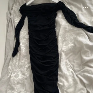 Svart klänning  - Elegant svart klänning med rynkade detaljer. Perfekt för en stilfull kväll. Klänningen har en åtsittande passform som framhäver figuren. 🖤