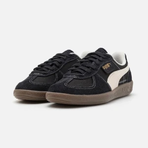 Svarta sneakers från Puma - Snygga svarta sneakers från Puma med vit sidostrimma och bruna sulor. I modellen Palermo vintage unisex sneakers! I storlek 40,5! I fint skick, säljer då jag behöver pengarna💗