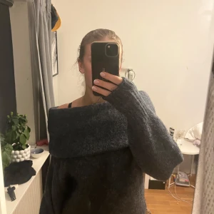 Mörkgrå stickad offshoulder-tröja - Säljer en mysig mörkgrå stickad tröja med offshoulder-design. Superfin knappt använd och bra kvalitet 