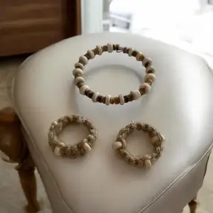 Snyggt armband med träpärlor i olika nyanser av brunt och beige. Perfekt för en naturlig och jordnära stil. Armbandet är elastiskt och lätt att ta på och av.