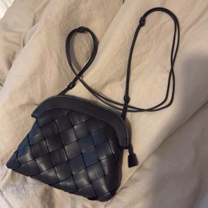 Svart flätad clutch väska från Carin Wester - Jätte fin Carin Wester flätad clutch bag 💘 köpt för 600kr på Åhléns , aldrig använd därav helt nyskick 😻helt slutsåld 💘