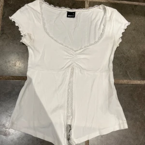 Vit topp med spetsdetaljer från Gina Tricot - Säljer en söt vit topp från Gina Tricot i storlek XS. Den är använd ungefär 3 gånger så den är som ny. Perfekt till en varm sommardag på grund av att den är väldigt luftig. Jag tycker verkligen att den är jättefin men bara inte på mig💓🌸
