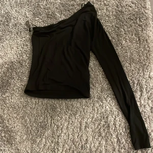 Svart oneshoulder topp - Snygg svart oneshoulder topp från Gina Tricot. Jättefint skick då jag inte använt den alls💞