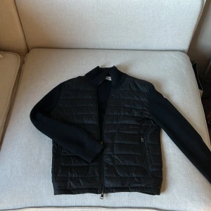Svart quiltad jacka från Moncler - Säljer nu denna feta moncler cardigan! Den är i väldigt bra skick ( 9/10 ) och de finns inga effekter på jackan. Jag köpte den på monclers hemsida för 8 400, har haft den i 1 år.
