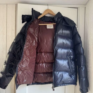 Svart dunjacka från Moncler - Säljer en snygg svart dunjacka från Moncler med en glansig finish. Perfekt för kalla dagar! Nypris är 18 000 är köpt runt hösten så är i nyskick. Kvitto finns men skickas endast vid köp.