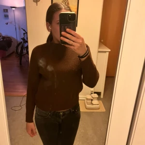 Brun stickad tröja - Mysig brun stickad tröja i mycket bra skick. Perfekt för höst och vinter med sin varma och bekväma design. Tröjan har långa ärmar och en klassisk passform som passar till det mesta. Ett måste i garderoben för kyliga dagar!