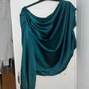 Grön/blå satinblus från Shein - Säljer en elegant grön/blå satinblus från Shein i storlek XL men kan passa som M. Blusen har en glansig finish och en lös passform som ger en lyxig känsla. Perfekt för festliga tillfällen eller en utekväll. Den har långa ärmar och en vacker drapering som ger en fin siluett. Kontakta mig för mer info eller köp direkt! 💚