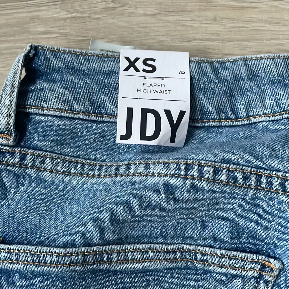 Säljer ett par snygga blå jeans från JDY i storlek XS. De är högmidjade och har en flared stil som ger en cool retro vibe. Perfekta för både vardag och fest! 🦋. Jeans & Byxor.