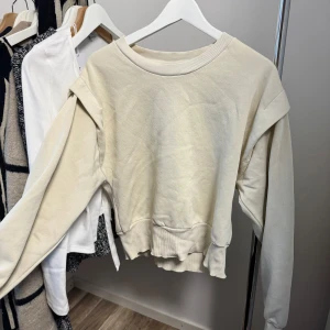Beige tröja från Gina Tricot - Säljer en supermjuk och bekväm beige tröja från Gina Tricot. Perfekt för mysiga höst- och vinterdagar. Tröjan har långa ärmar och en ribbad krage som ger en stilren look. Passar perfekt till jeans eller leggings för en avslappnad stil.
