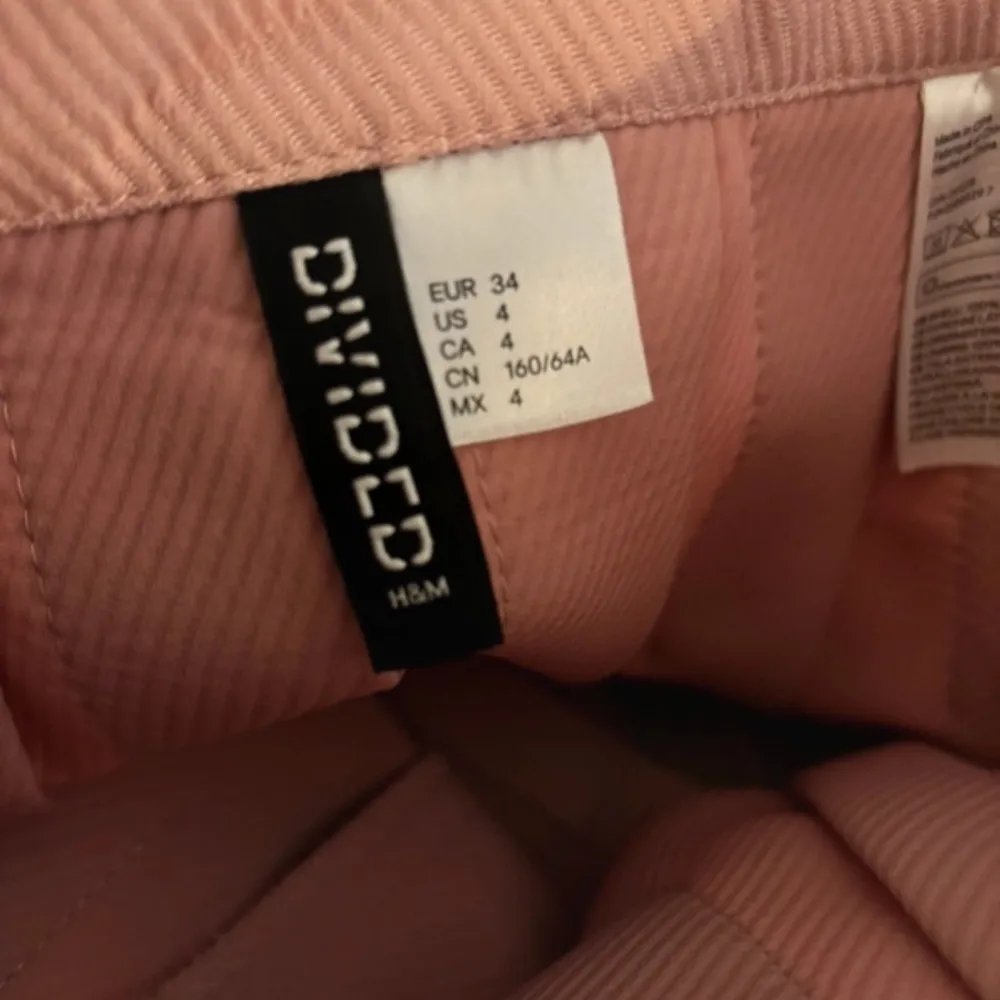 Superfin rosa kjol från H&M Divided i storlek 34. Den är gjord av polyester och har en söt design med vita ränder längst ner. Perfekt för vår och sommar! Kjolen har en normal passform och är i mycket bra skick. Har ett litet veck (se sista bilden) men inget man tänker på eller som syns så mycket. Köparen betalar frakt. . Kjolar.