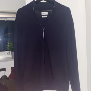 These Glory Days hel zip - Jag säljer denna  snygga hel zip från These Glory Days som är i en fin mörkblå färg och i merinoull. Tröjan är i bra skick enda deffekten är att den blivit nopprig men det går att fixa. STORLEK ”L” MEN PASSAR ”M”. Pris kan diskuteras vid snabb affär.
