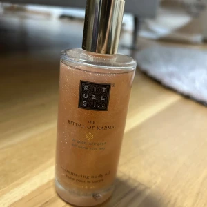 Rituals The Ritual of Karma Shimmering Body Oil - Säljer en flaska Rituals The Ritual of Karma Shimmering Body Oil. Den har en lyxig guldglittrande effekt och doftar fantastiskt. Perfekt för att ge huden en strålande lyster. Flaskan är elegant med en gyllene kork.