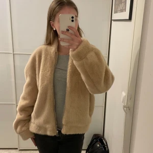 Beige teddyjacka från Bik Bok - Mysig beige teddyjacka från Bik Bok i mycket bra skick. Perfekt för höst och vinter med sin fluffiga och varma design. Jackan har en dragkedja framtill och långa ärmar. Den är i en normal passform och passar perfekt för en casual look. 🧥✨
