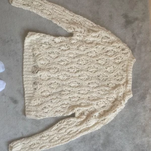 Beige stickad tröja från Zara - Säljer en superfin beige stickad tröja från Zara. Den har ett snyggt flätmönster och är perfekt för kyliga dagar. Tröjan är långärmad och känns både stilren och mysig. Passar perfekt till höst- och vintergarderoben!