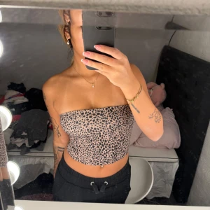 Leopardmönstrad tubtopp - Säljer en snygg leopardmönstrad tubtopp i mycket bra skick. Perfekt för en utekväll eller fest! Toppen är axelbandslös och har en tight passform som framhäver figuren. Materialet är mjukt och stretchigt för bästa komfort.