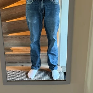 Levis 551 blå bra skick storlek 32/34 - Säljer ett par klassiska blå jeans i bra skick. De har en normal passform och är perfekta för vardagsbruk. Jeansen har en midwaist