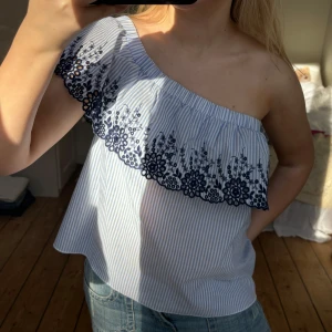 Volangtopp - Så fin volangtopp. Strl 38 enligt lapp, passar M o S. Man kan ha den antingen one shoulder eller som bild två. Lite lite missfärgad på ena axeln, de sista bild, men det syns knappt! 