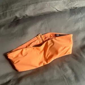 Säljer en snygg orange bikiniöverdel från Zara i storlek S. Den har en enkel och stilren design med en bandlös stil som ger en fin solbränna. 💕