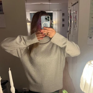 Beige stickad polotröja - Mysig beige stickad polotröja i mycket bra skick, förutom att den är lite nopprig. Tröjan har långa ärmar och ribbade kanter längst ut på ärmen.