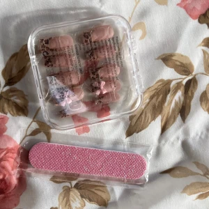 Nagelkit - Sött nagelkit med lösnaglar. Kommer i en praktisk rosa förvaringsask. Inkluderar en rosa nagelfil för enkel applicering och formning . Perfekt för speciella tillfällen.