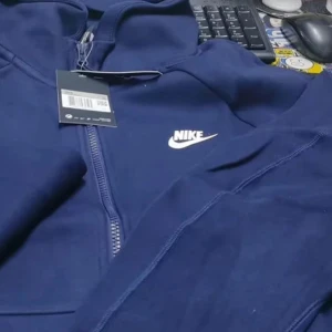 Mörkblå hoodie från Nike - Säljer en snygg mörkblå hoodie från Nike med dragkedja och huva. Den har en klassisk design med Nike-logga på bröstet och praktiska fickor framtill. Perfekt för en avslappnad stil.