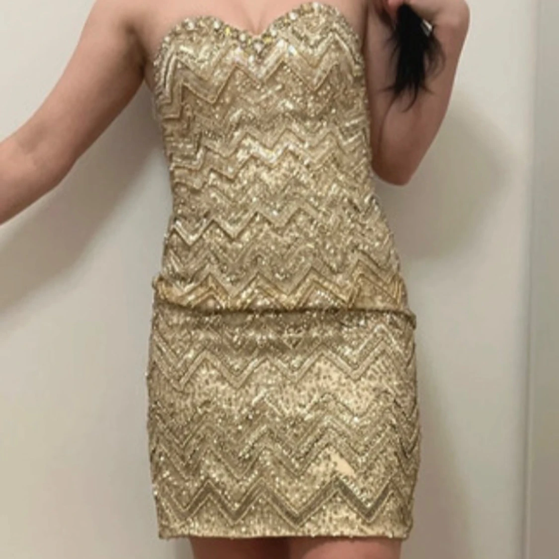 Glittrig axelbandslös klänning