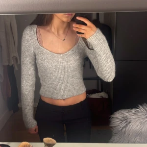 Grå stickad tröja från Gina Tricot - Säljer en snygg grå stickad tröja från Gina Tricot. Tröjan är croppad med en v-ringad design och har långa ärmar. Knappt använd! 💓