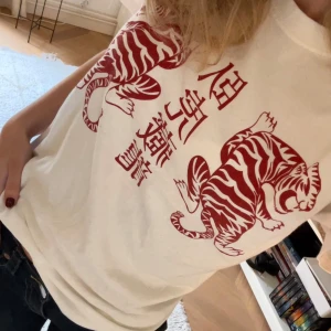 Graphic t-shirt - Säljer en vit t-shirt från Brandy Melville med coolt tryck i rött!! Den har korta ärmar och en normal passform ☺️