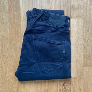 Replay anbass - Snygga svarta jeans från Replay med en klassisk femficksdesign. De har en knapp och dragkedja framtill och är tillverkade i ett bekvämt material som ger en bra passform. Perfekta för en stilren look.