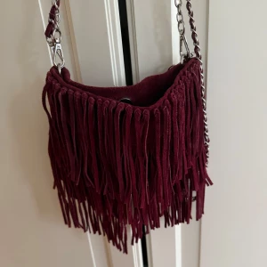 Fransväska - Så fin fransväska i mocka! Två band medföljer, ett kortare och ett längre, går att ta av och på 