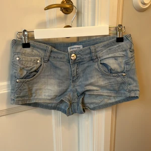 Blå jeansshorts  - Snygga blå jeansshorts från Verve med låg midja och coola detaljer . Jag säljer de här jättefina jeansshortsen från verve pga jag har ett par liknande men älskar dessa!💗