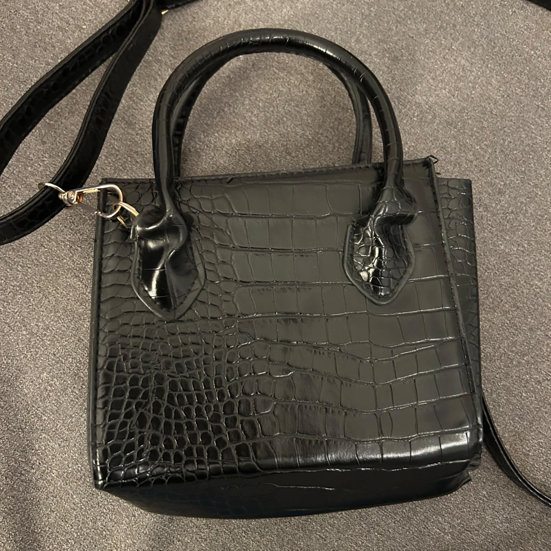 Svart axelväska med mönster