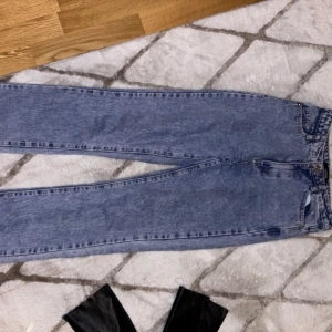 Blå jeansbyxor - Snygga blå jeansbyxor med klassisk design. De har en hög midja och en straight passform som ger en tidlös look. Straight jeans så pösiga men tight på midjan och bakdelen.