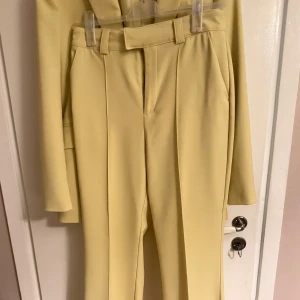 Gula kostymbyxor  - Snygg gul kostym med kavaj och matchande byxor. Kavajen har en klassisk design med knappar och byxorna har en stilren passform med bälte. Perfekt för en färgglad och stilren look.snygga kostymbyxor från Gina, nypris 400✨ endast använda en gång👌🏼Säljer kavajen separat‼️