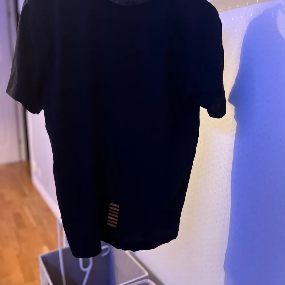 Snygg svart t-shirt från EA7 med gul logga på bröstet. Perfekt för en stilren och avslappnad look. T-shirten har en klassisk passform och är kortärmad. Välkommen att diskutera pris om det är så. . T-paidat.