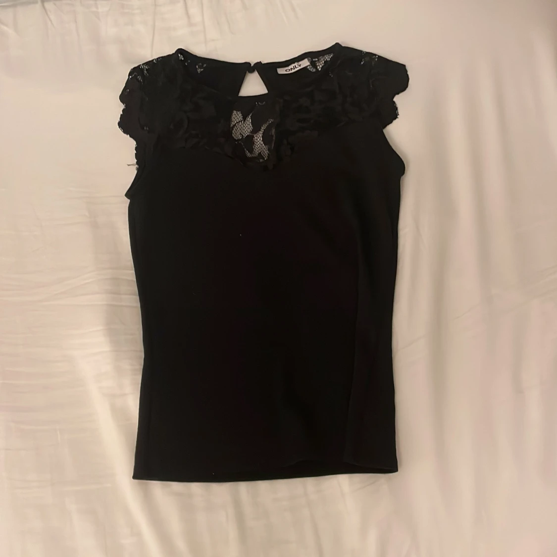 Svart topp med spetsdetaljer från Only