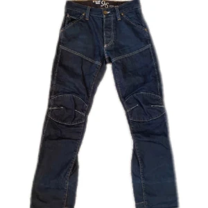 Mörkblå jeans från G-Star RAW - Säljer ett par snygga mörkblå jeans från G-Star RAW. De har en cool design med stora fickor bak och förstärkta knän. Perfekta för en y2k look. Jeansen har en normal passform och är i mycket bra skick. Passar perfekt till höst och vår! Sista bilden är exempel på hur den ungefär sitter! Bootcut sitter under naveln- medium low waist.                   ORGINAL PRIS NYA: ca. 1400kr 