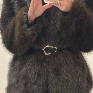 Brun pälsjacka med bälte - Snygg brun pälsjacka med ett elegant bälte i midjan. Jackan har långa ärmar och en mjuk, fluffig textur som ger en lyxig känsla. Perfekt för att hålla sig varm och stilren under kallare dagar.