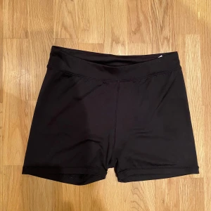 Svarta träningsshorts - Snygga svarta träningsshorts i syntetmaterial. De har en tight passform och är normala i midjan. För små för mig! 💗