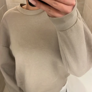 Beige sweatshirt från Ginatricot - Säljer en stilren beige sweatshirt från Ginatricot. Tröjan har en rund halsringning och långa ärmar med ribbade muddar. Perfekt för en avslappnad look. Passar bra till jeans eller leggings.