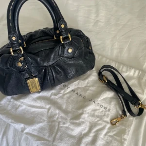 Marc Jacobs väska  - Säljer min Marc Jacobs väska då den inte längre kommer tlll användning. Fint skick och jag har dust bag och långa bandet! Möts i Sthlm