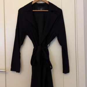 Bikbok trench coat kappa - Svart trench coat kappa från bikbok i storlek XS. Använd en gång. 