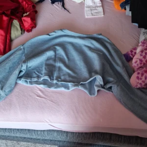 Grå croppad tröja från H&M Divided - Säljer en superfin grå croppad tröja från H&M Divided. Den är perfekt för en avslappnad stil och har långa ärmar. Materialet är mjukt och bekvämt, vilket gör den idealisk för både vår och sommar. Passar perfekt till ett par höga jeans eller shorts!