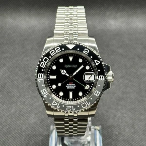 GMT Wayne Mod - GMT Wayne Mod Denna klocka är en modifiering.  Varje del är ny.  Info om boetten:  Diameter: 41mm Svart urtavla med luminiscens. Tim och minutvisare är lysande.  Klockan har Safirglas.   Info om urverket: Seiko Nh34 (automatisk) 
