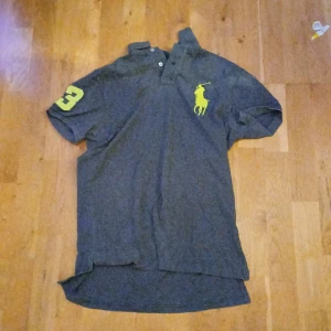 Ralph lauren piké - En ralph lauren piké som e grå och neon gul använd ganska många gånger, storlek M. 