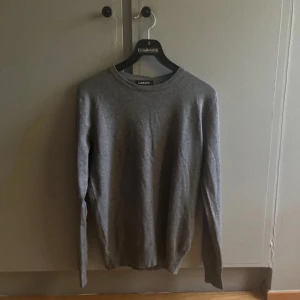 Grå stickad tröja - Säljer en grå stickad tröja i nyskick, helt oanvänd. Ingen aning vilket märke det är.