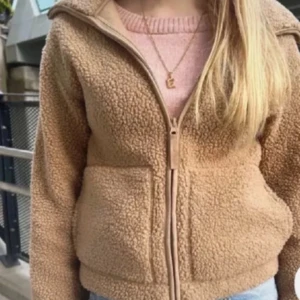 Beige teddyjacka med dragkedja - Mysig beige/rosa teddyjacka med dragkedja framtill och två stora fickor. Den är väl använd, Det är ett litet hål i armen❣️