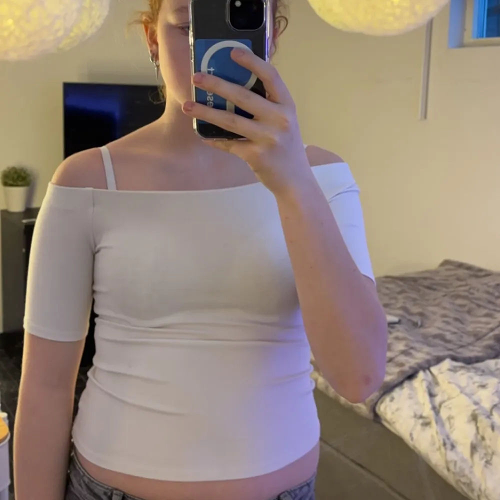 Säljer en stilren vit offshoulder topp med korta ärmar. Perfekt för en somrig look. Toppen är tight och framhäver figuren.. Yläosat.