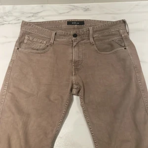 Replay - Snygga beige jeans från Replay i modellen Anbass. De har en klassisk femficksdesign och knappgylf. Perfekta för en avslappnad stil. Bra skick på dem säljer dem för 399kr lägsta jag kan tänka mig gå är 190